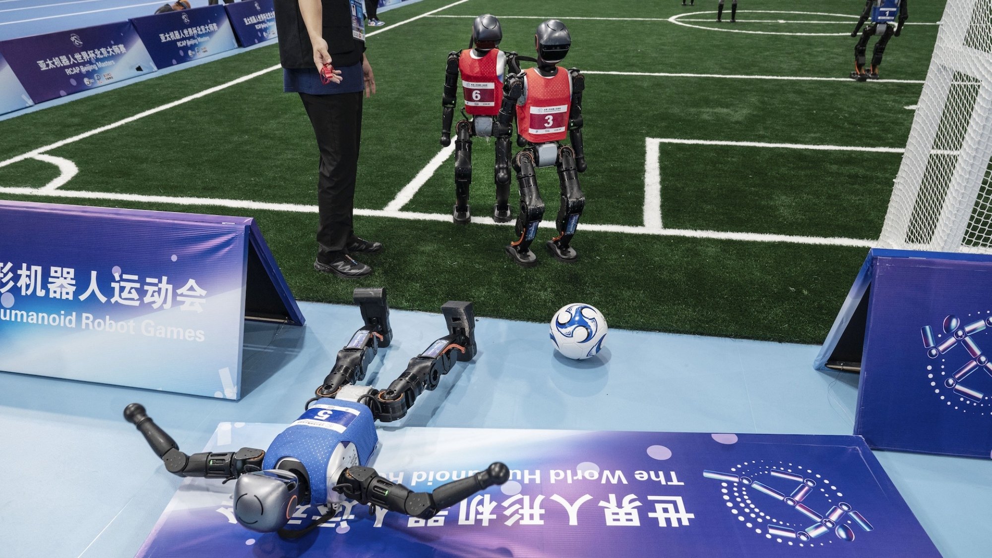Robot bermain sepak bola di pertandingan robot Humanoid World 2025.
