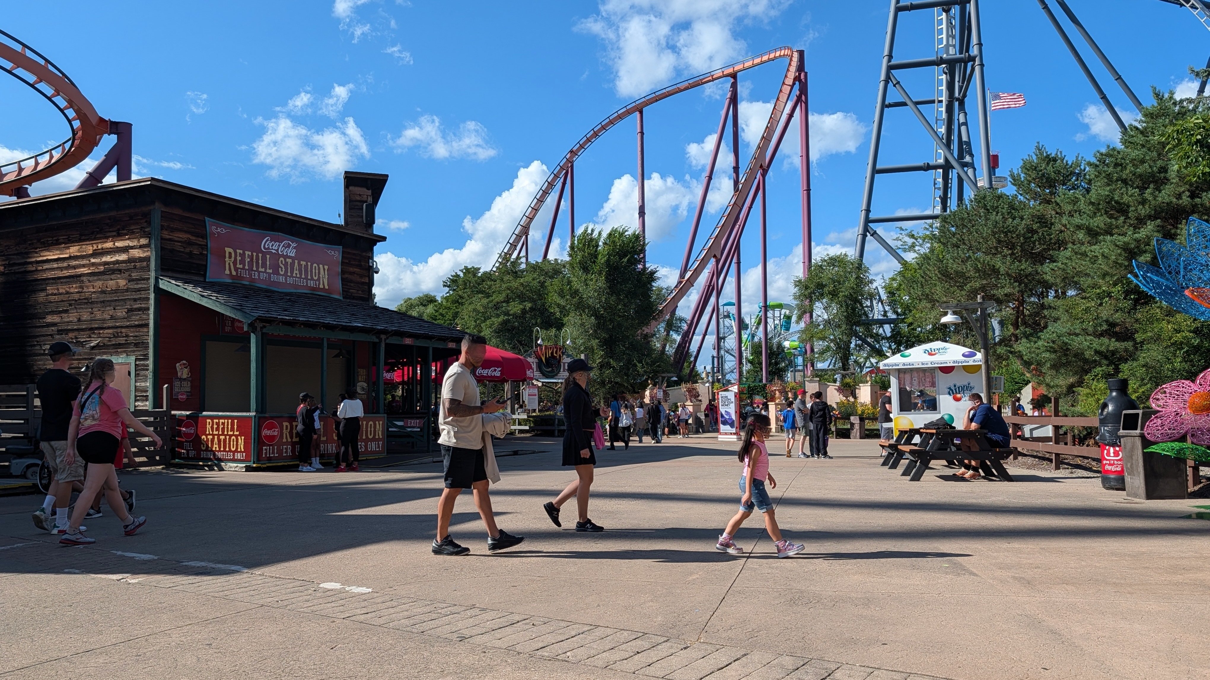 taman hiburan dengan orang dan roller coaster
