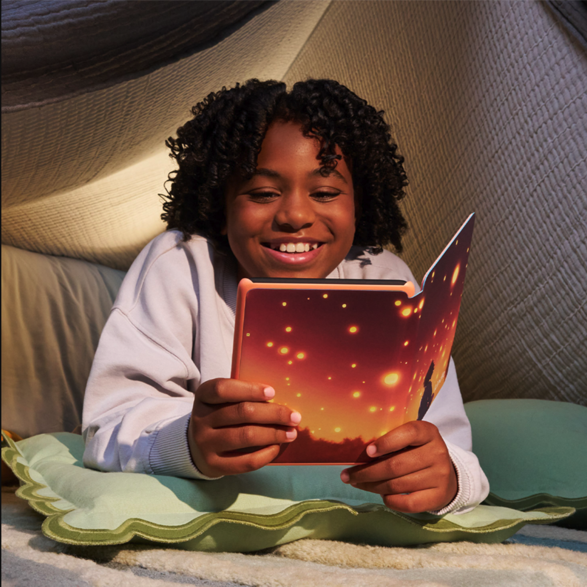Gadis muda membaca di Kindle Colorsoft Kids dengan Starlight Reading Cover.