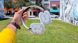 Tangan pria tidak memegang apa pun headphon (1) di depan rumput