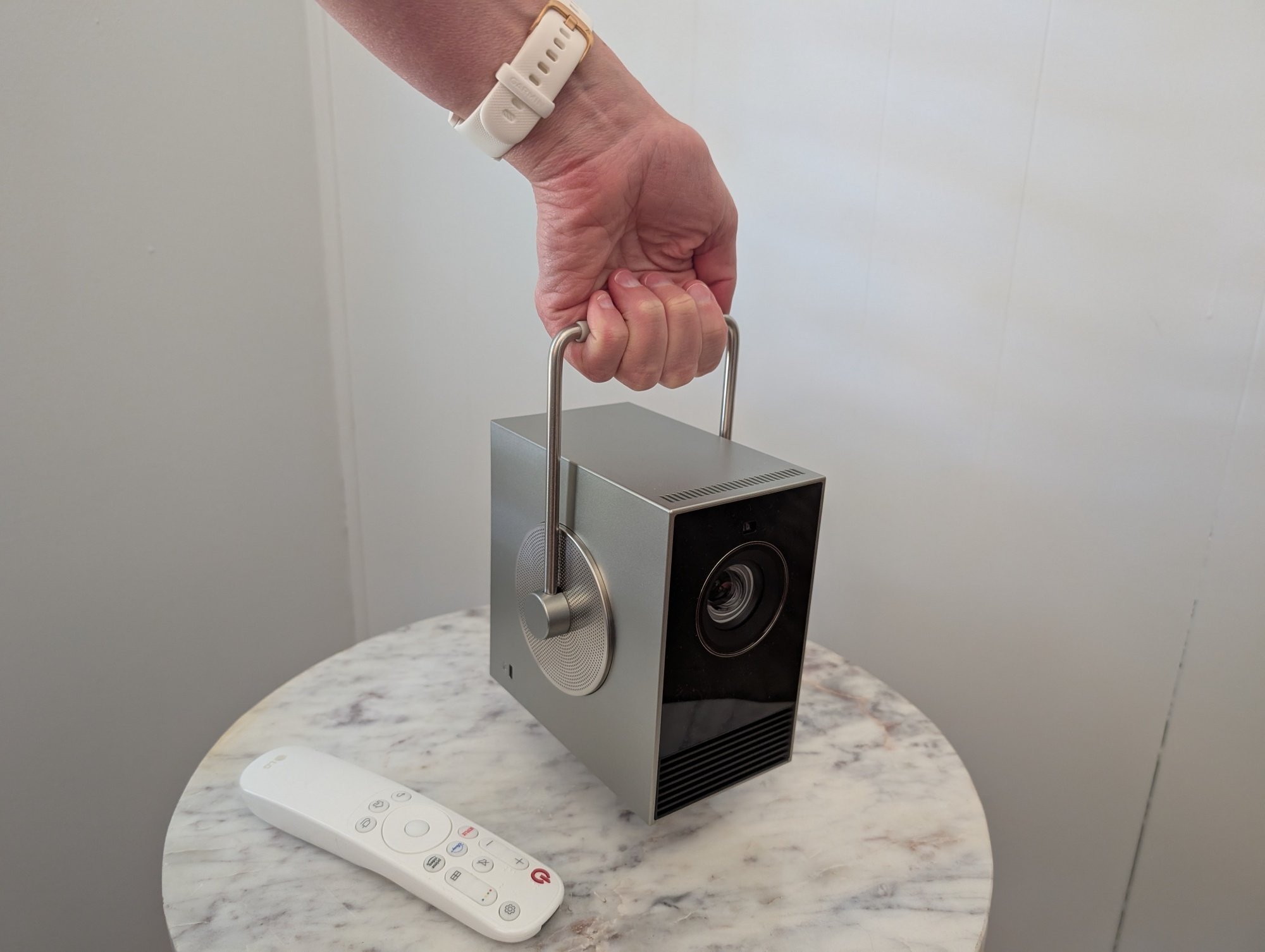 Tangan memegang pegangan pada proyektor Cinebeam Q 4K LG